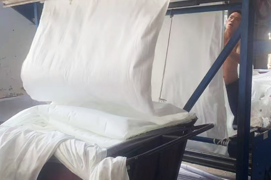 Producción en fábrica de teñido: área de giro de tela gris